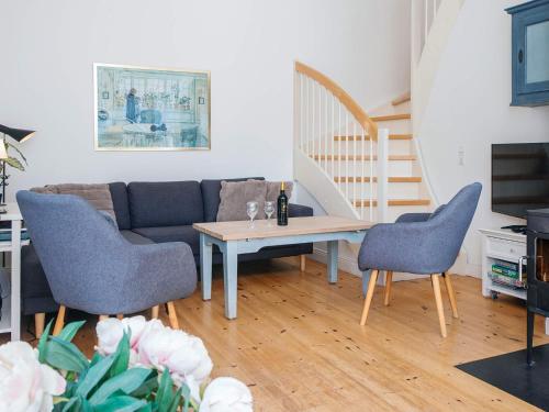 a living room with a couch and a table and chairs at 4 star holiday home in Ringkøbing in Ringkøbing