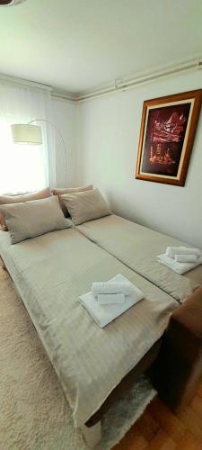 a large bed with two white towels on it at Apartman Layla in Bihać