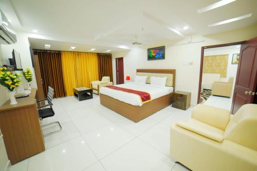 a hotel room with a bed and two chairs at The EMBASSY HOTEL in Guntūr