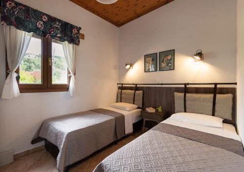 a bedroom with two beds and a window at House Demetra in Astris
