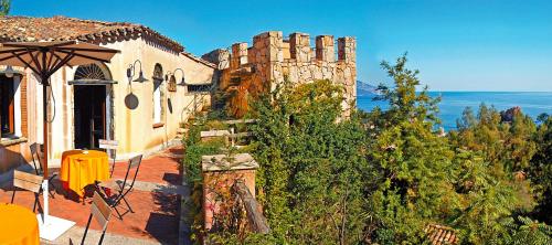 an old building with an umbrella in front of it at Hotel Monte Turri - Adults Only in Àrbatax