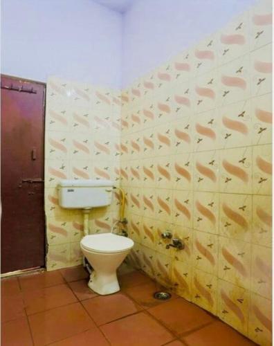 a bathroom with a toilet in a room at Hotel cozy guest house in Alīgarh