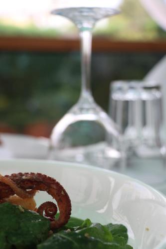 a plate of food on a table with a wine glass at Orchidea Hotel in Tirana