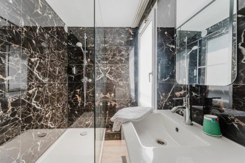 a bathroom with a white tub and a glass shower at Logis Hôtel & Restaurant Cap Hôtel in Noyelles-Godault