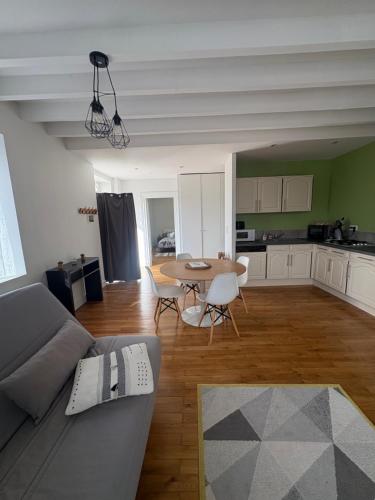 a living room with a couch and a table at Bienvenue dans le Beaujolais in Le Perréon
