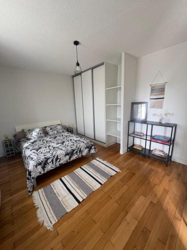 a bedroom with a bed and a wooden floor at Bienvenue dans le Beaujolais in Le Perréon