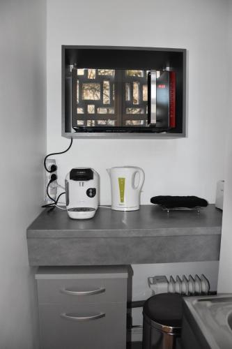 - un comptoir de cuisine avec un grille-pain et des tasses dans l'établissement La Forclaz, à Annecy