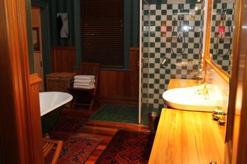 uma casa de banho com uma banheira e um lavatório e uma banheira em Villa Rouge B&B em Invercargill