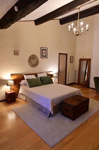 a bedroom with a large bed and a chandelier at L'Oustal des Rameaux in Brissac