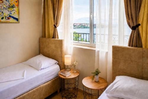 a small room with two beds and a window at Effect Saint Mina - SELF CHECK-IN in Sozopol
