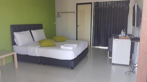 um quarto com uma cama com duas almofadas em The Clover Lampang em Lampang