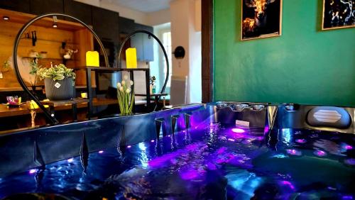 a blue tub with purple lights in a room at Ecrin d'exception avec jacuzzi et salon cinéma in Penne-dʼAgenais