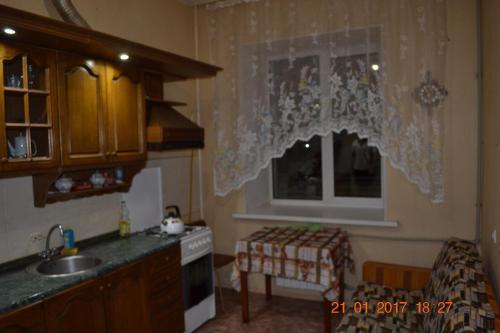 ヴォログダにある2 Rooms Gagarin apartamentsのキッチン(シンク付)、窓