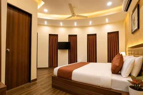 a bedroom with a bed and a ceiling at Hotel Shiv Shakti in Rajkot