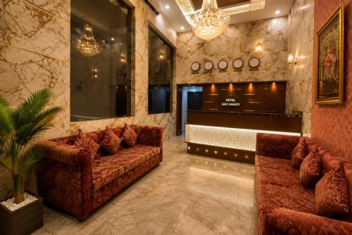 a lobby with two couches and a bar at Hotel Shiv Shakti in Rajkot