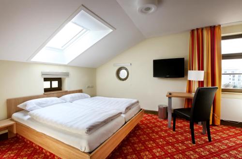 a bedroom with a bed and a desk and a tv at Bahnhof Busch in Bretzfeld