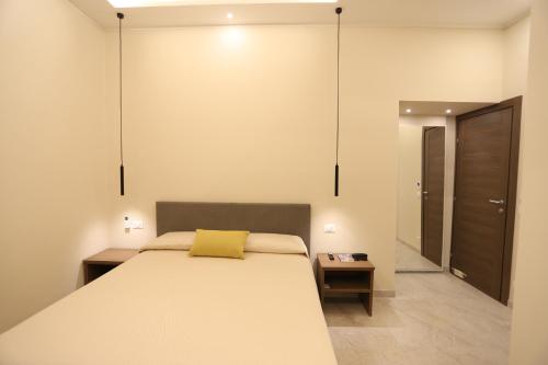 a bedroom with a bed with a yellow pillow on it at Palazzo Campisi rooms in Tropea