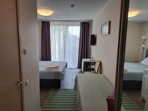 a hotel room with two beds and a window at Aisa Street apartments in Pärnu