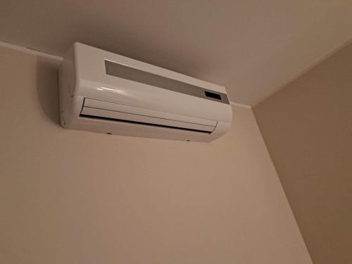 a white air conditioner on the ceiling of a room at Aisa Street apartments in Pärnu