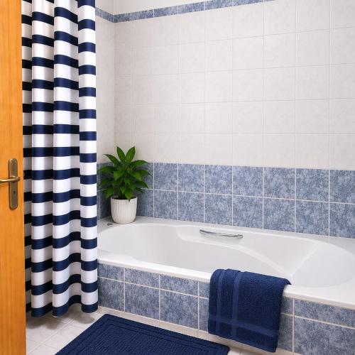 a bathroom with a bath tub and a plant at Villa Athena in Peyia