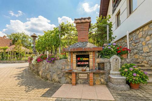 a brick oven with flowers on the side of a building at Vrtin Vineyard Family Retreat - Happy Rentals in Dragatuš