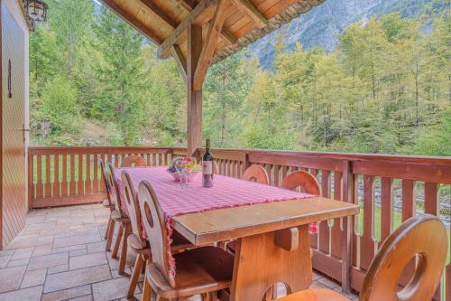 ein Holztisch auf einer Terrasse mit einer Flasche Wein in der Unterkunft Chalet Primus in Soča Valley - Happy Rentals in Soča