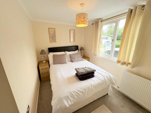a bedroom with a white bed with a window at caddys lodge in Tydd Saint Giles