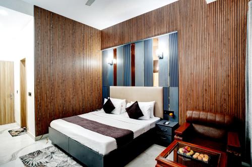 a hotel room with a bed and a chair at Hotel Rivlet By Carlton Suites in Gurgaon