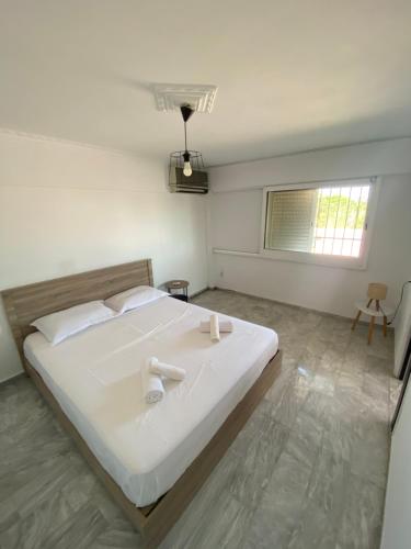 a bedroom with a large white bed and a window at Selinia Apartments in Selínia