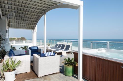 a deck with a hot tub and chairs on a balcony at Blu Suite Resort in Bellaria-Igea Marina