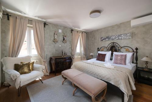 a bedroom with a large bed and a chair at Villa San Martein in Rovinj