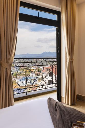 a bedroom with a large window with a view at AuraLite Hotel - Panorama View Đà Lạt in Da Lat
