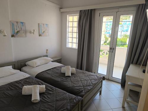 a hotel room with two beds and a window at Renia Studios - Pool & Beach in 150m - Agia Pelagia in Agia Pelagia