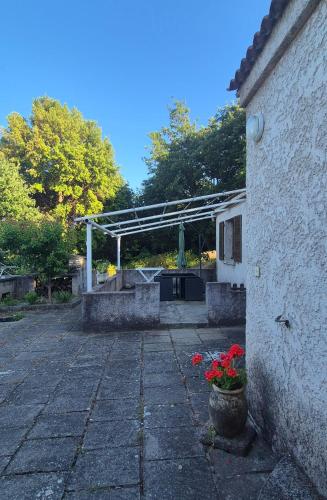 a stone patio with a pergola and flowers at Maison T3 Bastia Sud, Casamozza in Monte