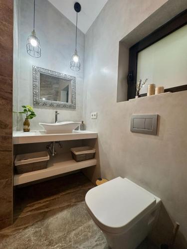 a bathroom with a white toilet and a sink at Casa do Alambique in Alvaredo