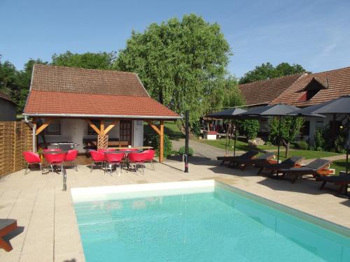 a swimming pool with a table and chairs and a house at Remser Haus in Zalakaros