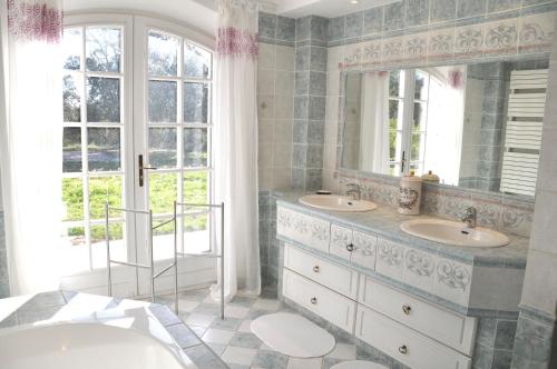 a bathroom with two sinks and two mirrors at Villa 342 m2 classée 4 étoiles sur 1 ha - Provence in Besse-sur-Issole