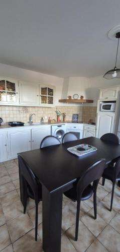 a kitchen with a black table and chairs in it at Maison T3 Bastia Sud, Casamozza in Monte