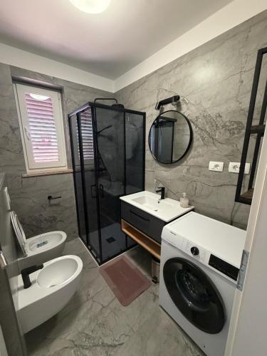 a bathroom with a sink and a toilet and a shower at Nela Apartment in Rabac