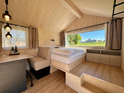 a small room with a bed and a desk at Die Tinys - Ferienhäuser am Attersee in Nussdorf am Attersee