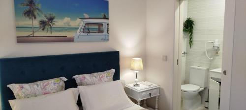 a bathroom with a blue headboard and a bathroom with a toilet at A Casa da Ti Laura - AL in Aveiro