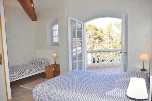 a bedroom with two beds and an open door at Villa 342 m2 classée 4 étoiles sur 1 ha - Provence in Besse-sur-Issole