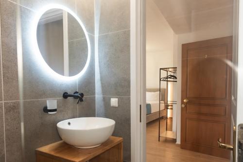 a bathroom with a white sink and a mirror at Pelagos Suites in Igoumenitsa