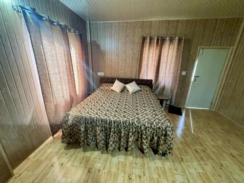 a bedroom with a bed and a wooden floor at Nalari Resort in Borpāni