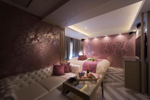 a bedroom with a bed and a couch and a table at Hotel Zen Rikyu Yokohama Hazawa in Yokohama