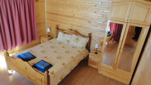 a bedroom with a bed and a wooden wall at BUNGALOWS SKI PISTA Govedarci in Govedartsi