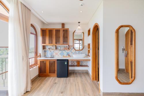a kitchen with a sink and a counter with mirrors at Lúa Boutique Hoi An Hotel in Tân Thành (1)