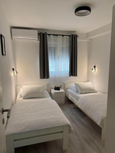 una camera da letto con due letti e una finestra di Mendula a Spalato (Split)