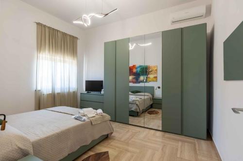 a bedroom with a bed and a mirror at Sweet Nonna Dora Corato - Casa con Parcheggio in Corato