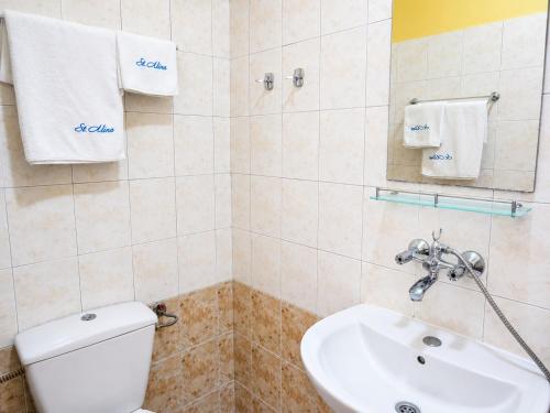 a bathroom with a white toilet and a sink at Effect Saint Mina - SELF CHECK-IN in Sozopol